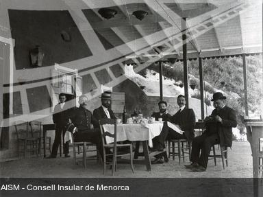 [Grup d'homes en una taverna del Fonduco del port de Maó]. [Fotografia]